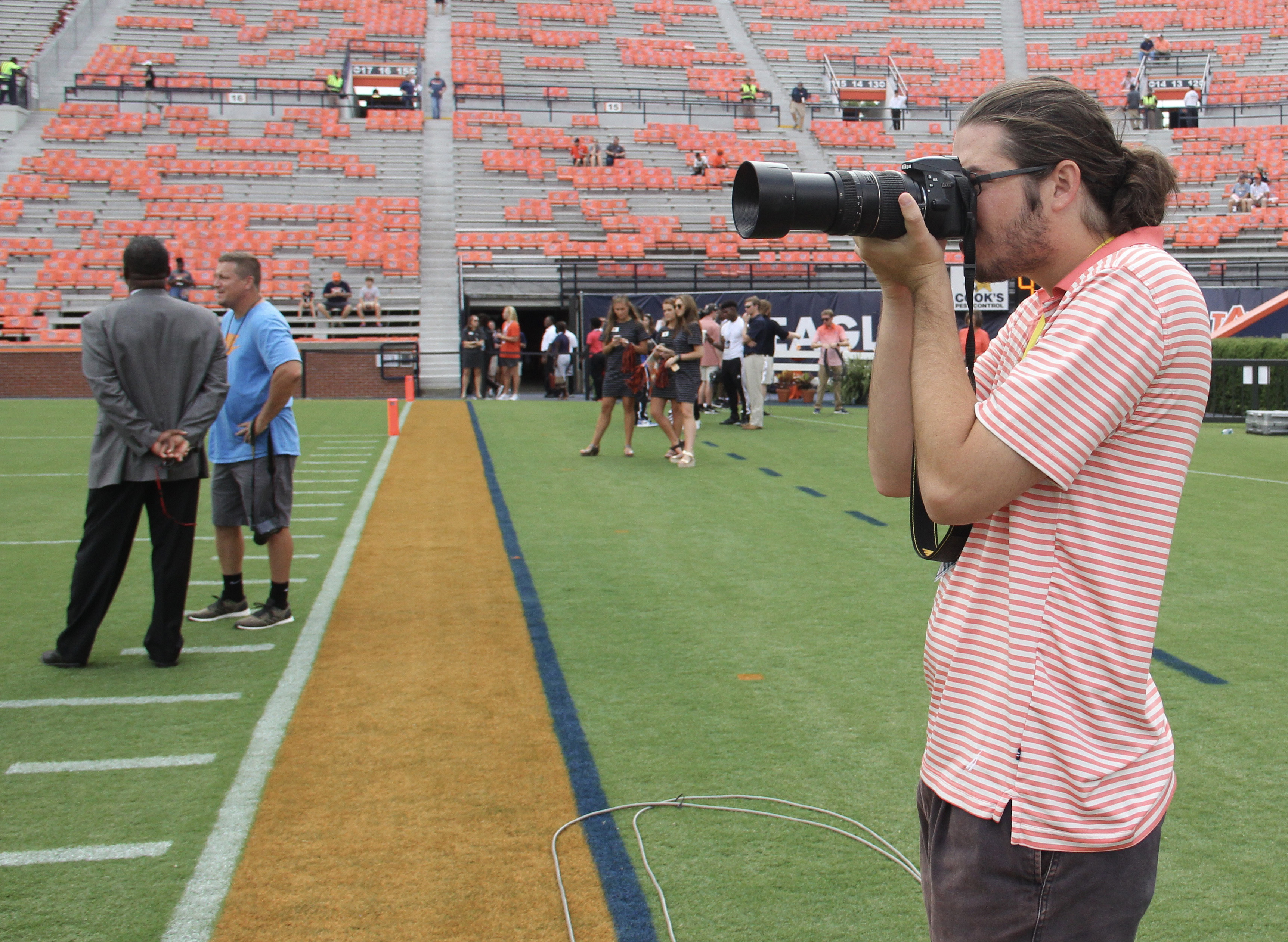 Wolk incorporates several tools of the trade when covering college football including photography and Facebook Live.
