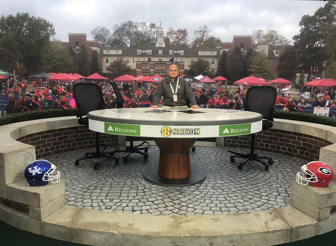 Reiter poses for a picture at the SEC Nation desk when the network visited campus before the University of Georgia vs. University of Kentucky game.