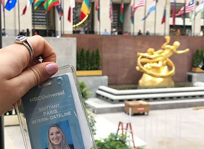 Brittany Paris holding her Dateline NBC internship badge in Rockefeller Center.