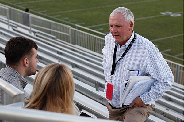 Bob Houghton talks with students at a game. 