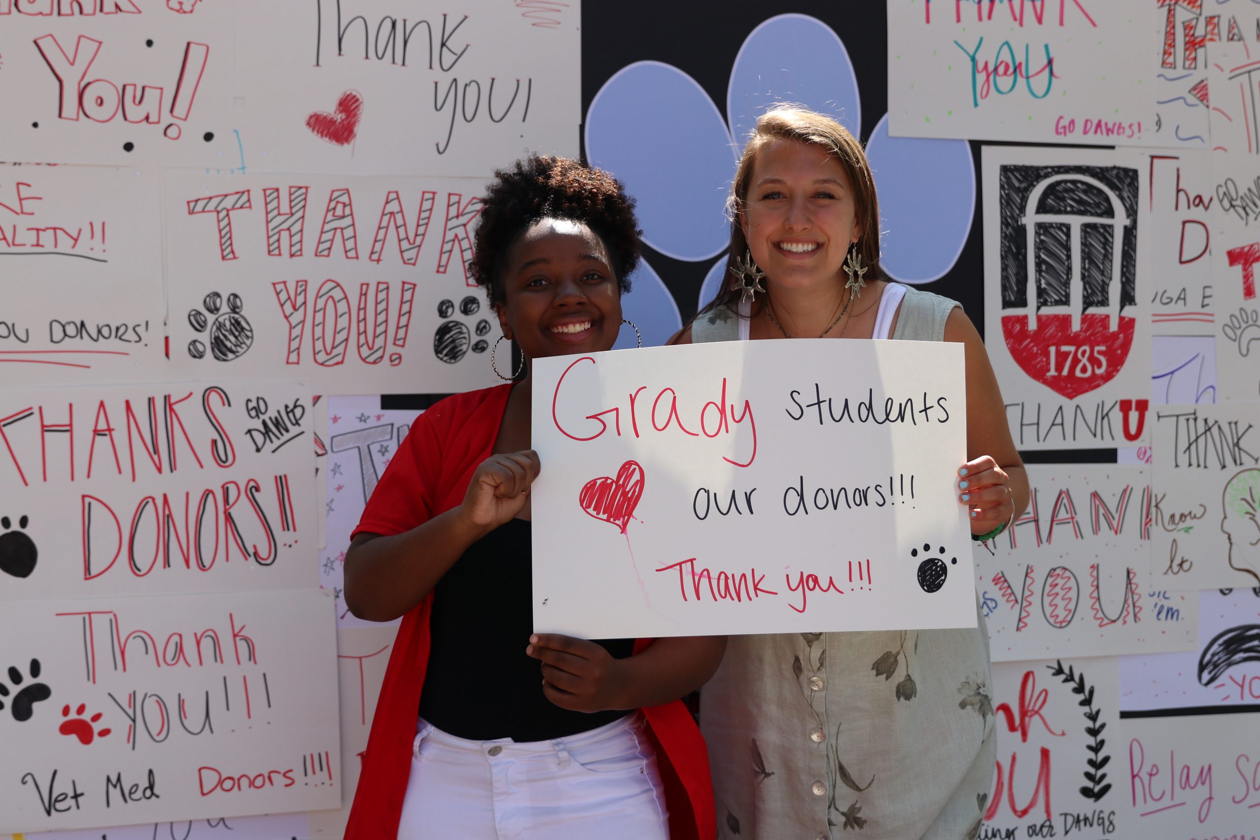 Students hold a sign thanking Grady College donors.