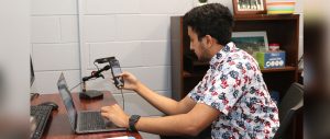 Charan Ramachandran sits at a computer and eye-tracking recorder.