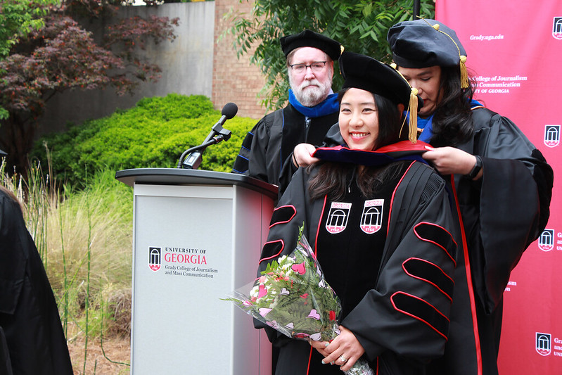 Dr. María E. Len-Ríos places a stole on a graduating student during Grady graduation in spring 2022.