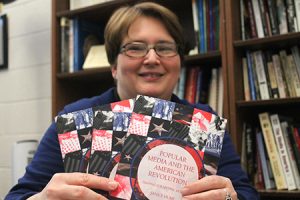 Janice Hume holds copies of her book, "Popular Media and the American Revolution."