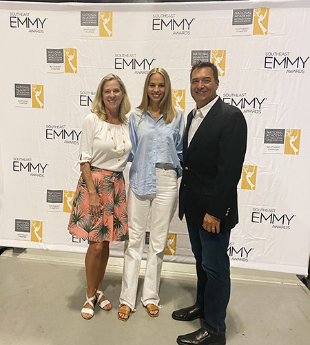 Campbell Johnson with her parents, Kay and Dan Johnson in front of an EMMY step and repeat
