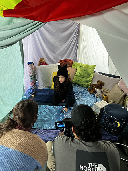 Two people film a girl in a tent for Elise Nation's thesis film, "Poppy."