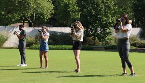Students practice their photo skills outside.