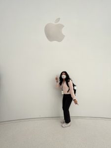 Suley poses in front of a white wall with the Apple logo 