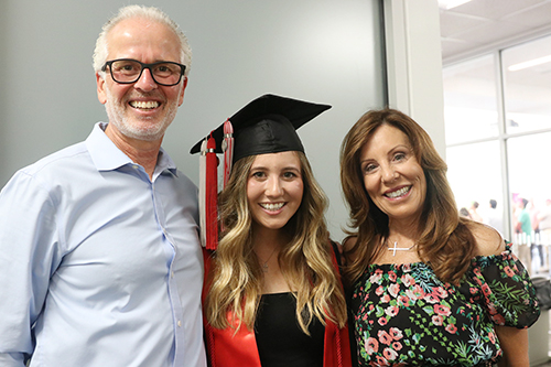 Sam Perez in her graduation cap and gown with her parents Rob and Diane.