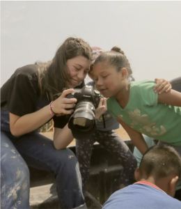 Oney shows a photo on her camera to a young girl in Ensenada, Mexico. 