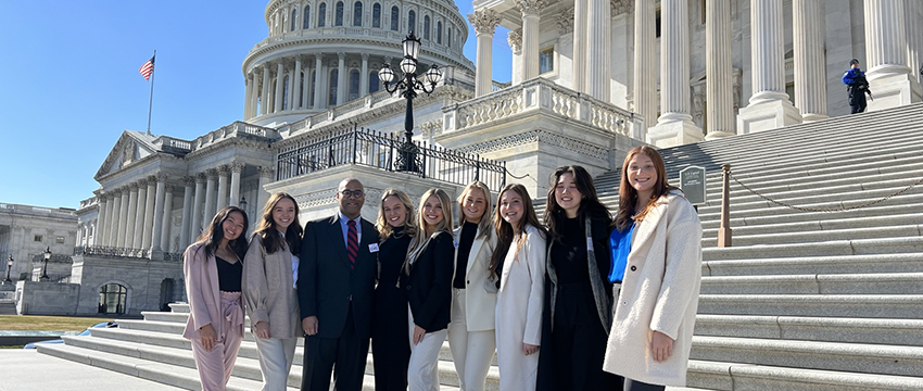 A group of UGA PRSSA students studying public relations with Professor Joe Watson in front of the U.S. Capitol.
