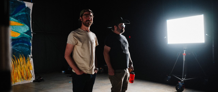 Matt Hudgins (right), holding a refillable water bottle, and producer Andrew Hunter on stage at Athena Studios