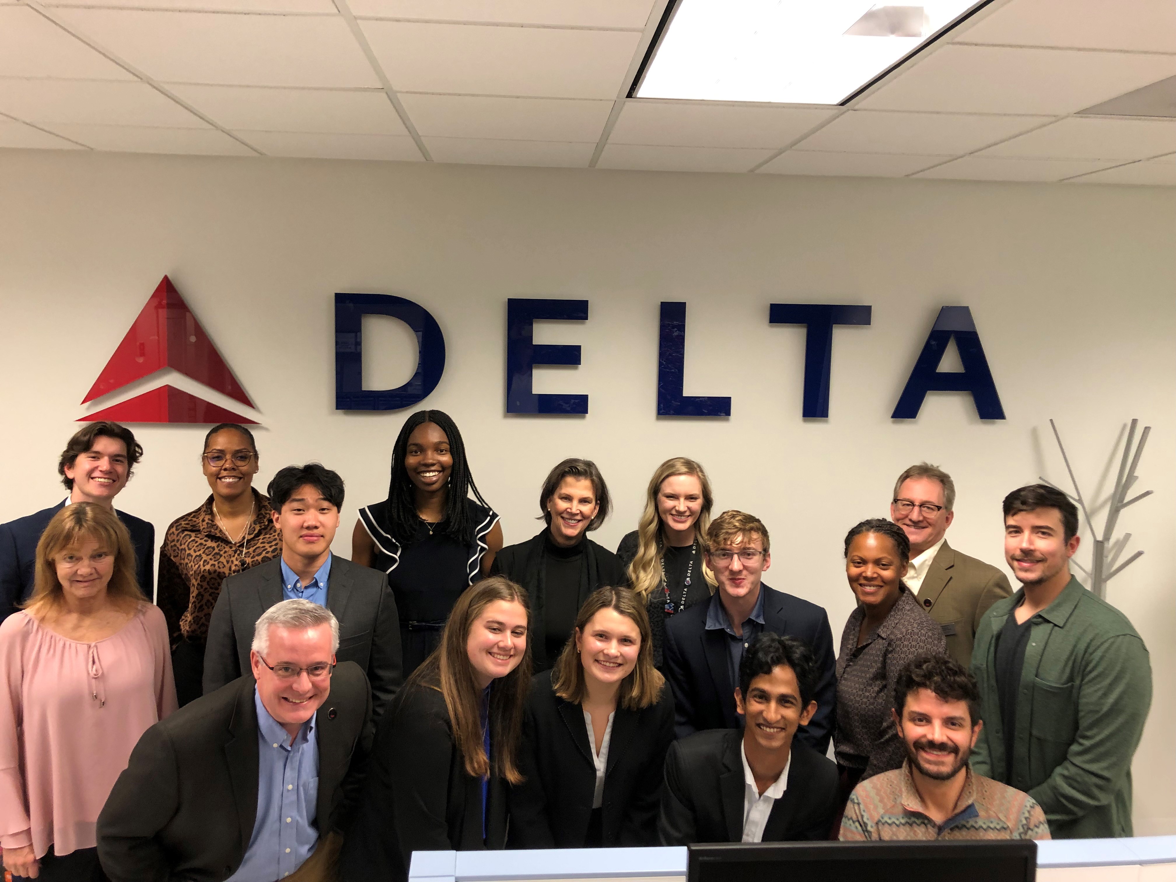 Chiamaka Uwagerikpe poses with a group of people in front of the Delta sign. 
