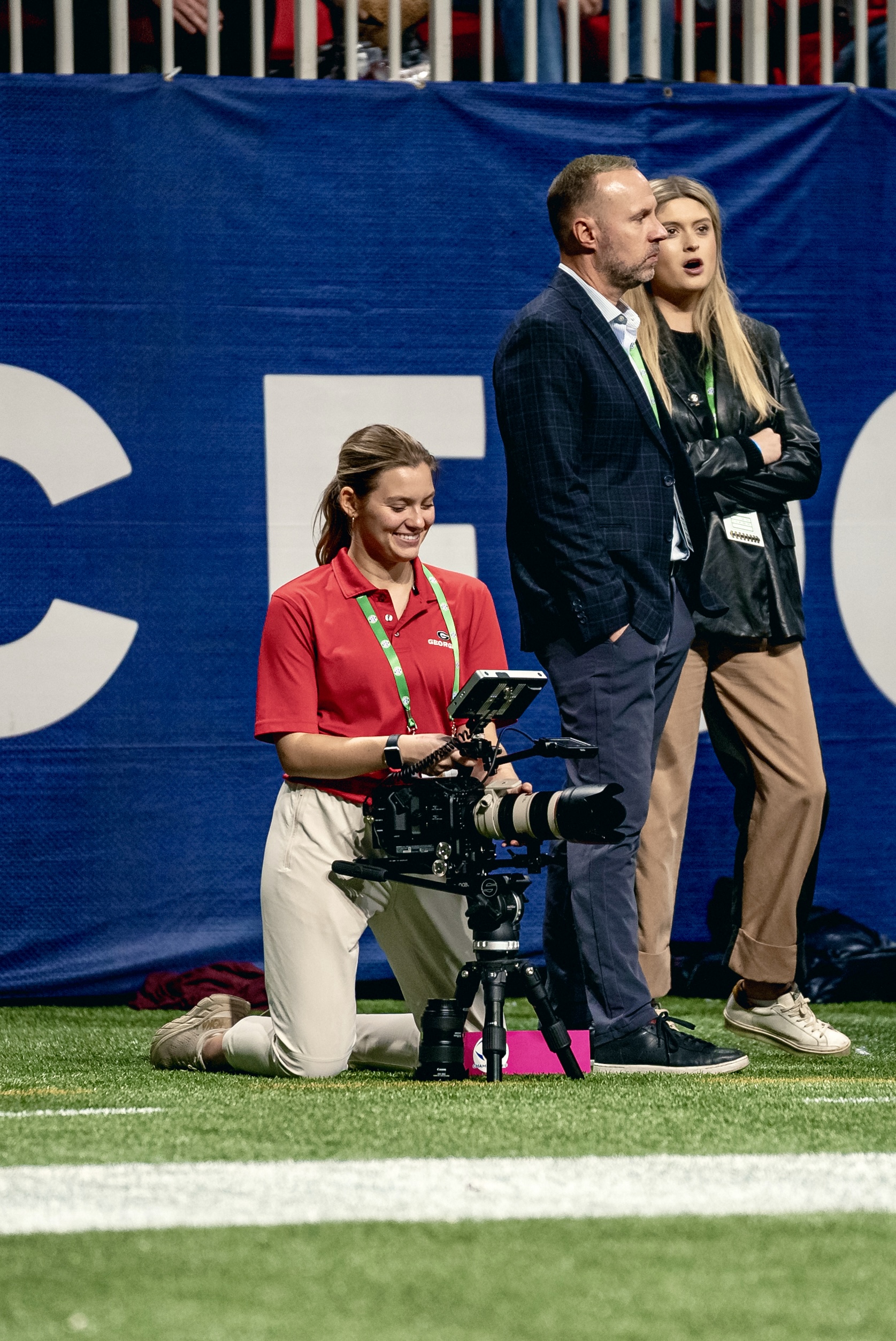 student filming on the sidelines of a UGA football game. 