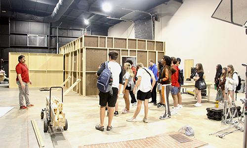 Students tour Athena Studios, with a house set in the background.