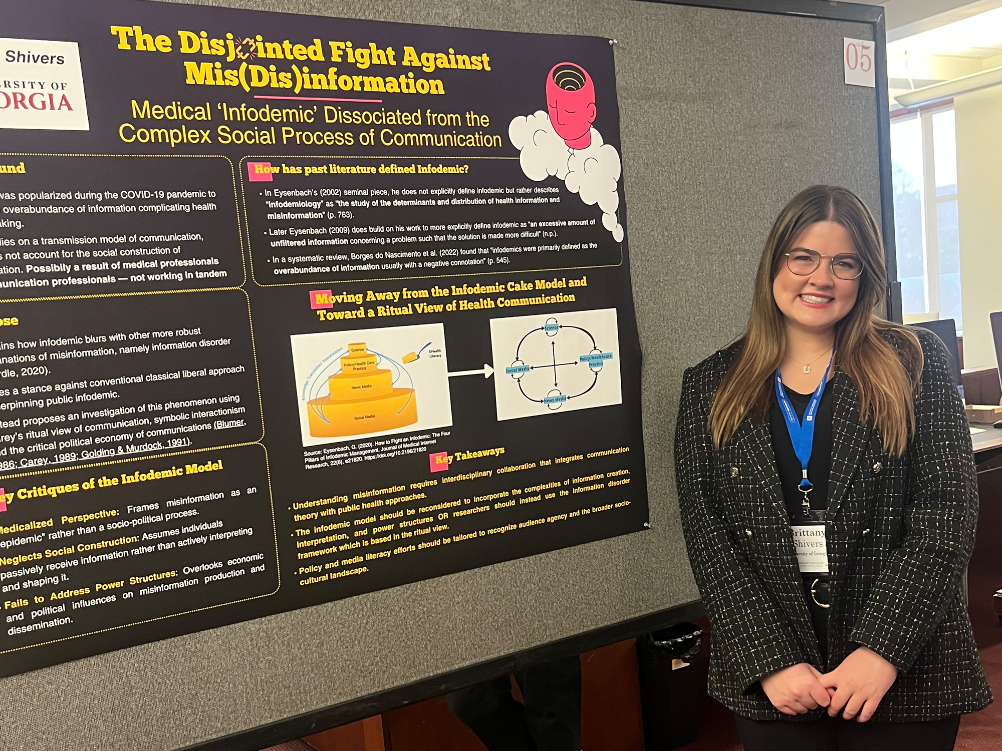 Brittany Shivers poses for a pictures in front of one of her research posters.