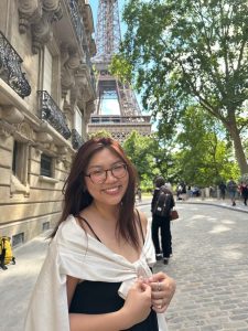 Photo of Deborah Yoon standing in front of the Eiffel Tower 
