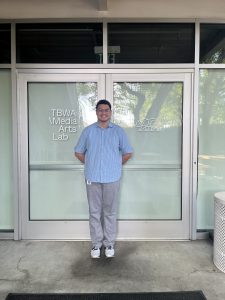 Blake Campbell stands in front of the doors to TBWA \ Media Arts Lab