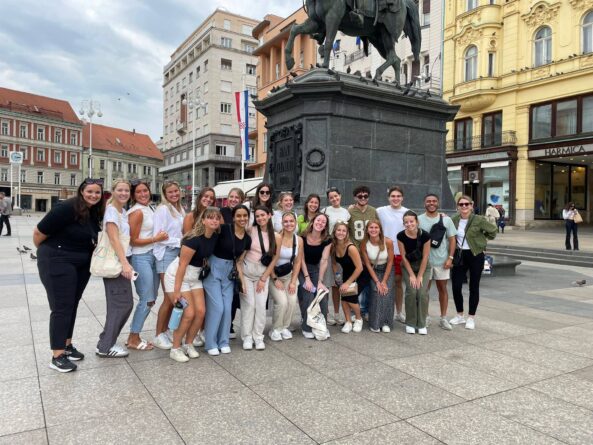 Students on the International Mass Communication in Croatia Study Abroad Program pose in front of a statue in Croatia