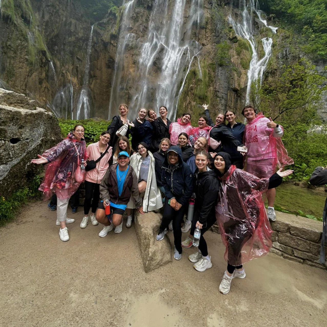 A group in front of a waterfall in Croatia.