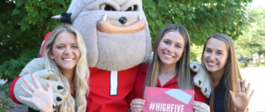 Students stand with Hairy Dawg holding a High Five graphic.
