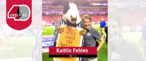 Kaitlin Febles on the football field with the Chick fil A cow.