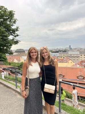 Two students on the International Mass Communication in Croatia Study Abroad Program pose in front of Croatian buildings and landscape.