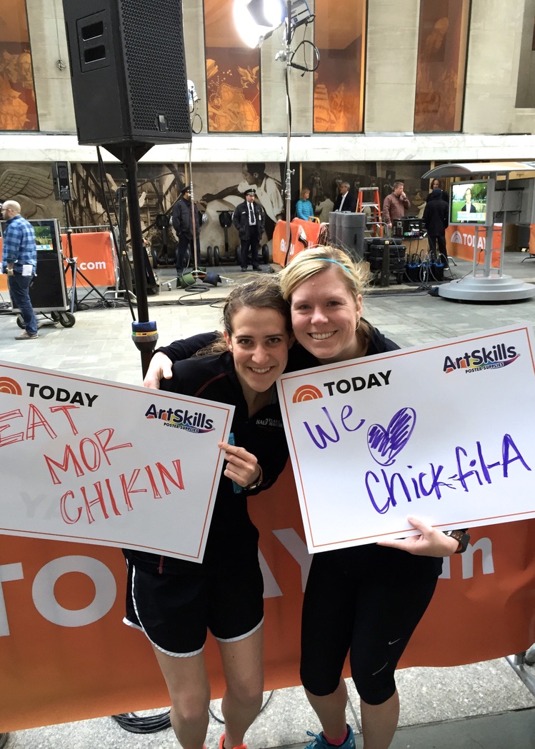 Kaitlin Febles and a work colleague hold signs in the TODAY Show Plaza.
