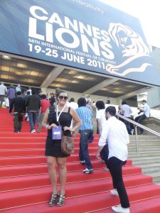 Mallory O'Brien standing on red carpeted stairs at the Cannes Lions Film Festival.