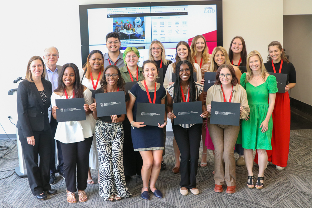 A group of students wearing medals and holding certificates that read Cox Institute for Journalism Innovation, Leadership and Management.