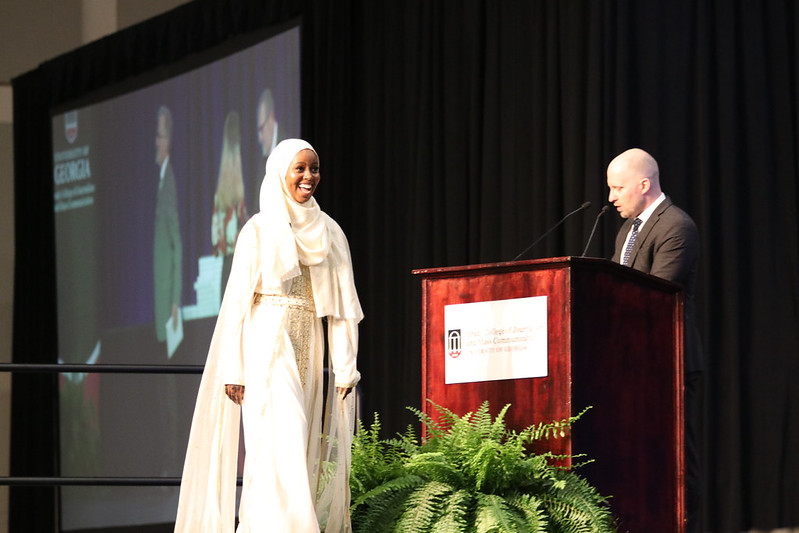 Fardosa Hassan crosses the stage at the Spring 2023 Grady College Convocation as Matthew Evans calls her name. (Photo: Sarah E. Freeman) 