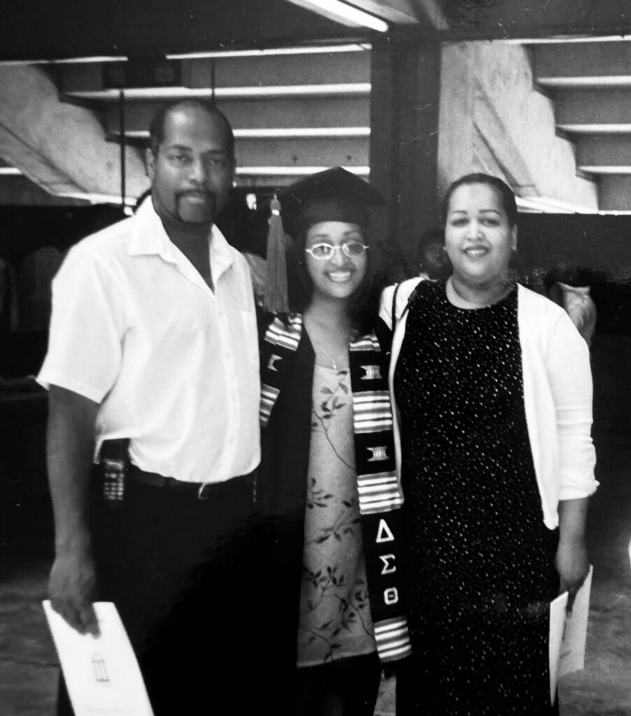 Marie Hunter stands with her parents on graduation day in 2002.