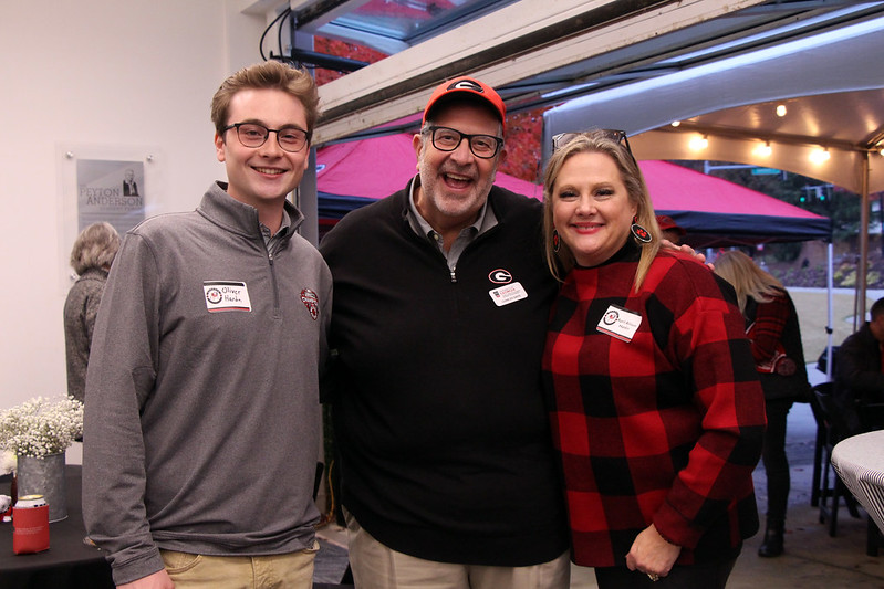 Dean Davis poses for a photo with two others at the 2023 alumni tailgate in the PAF.