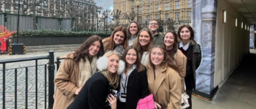 Lila (left) and other students on the program on a day-trip to London visiting the British Parliament. They are standing together for a group photo.