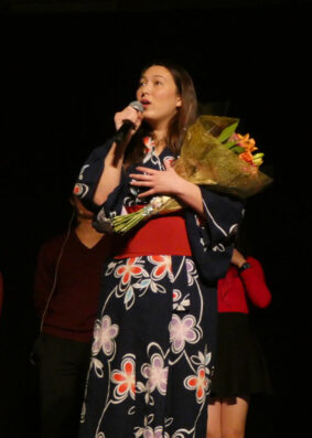 Siena Miyaura holds flowers and talks into a microphone