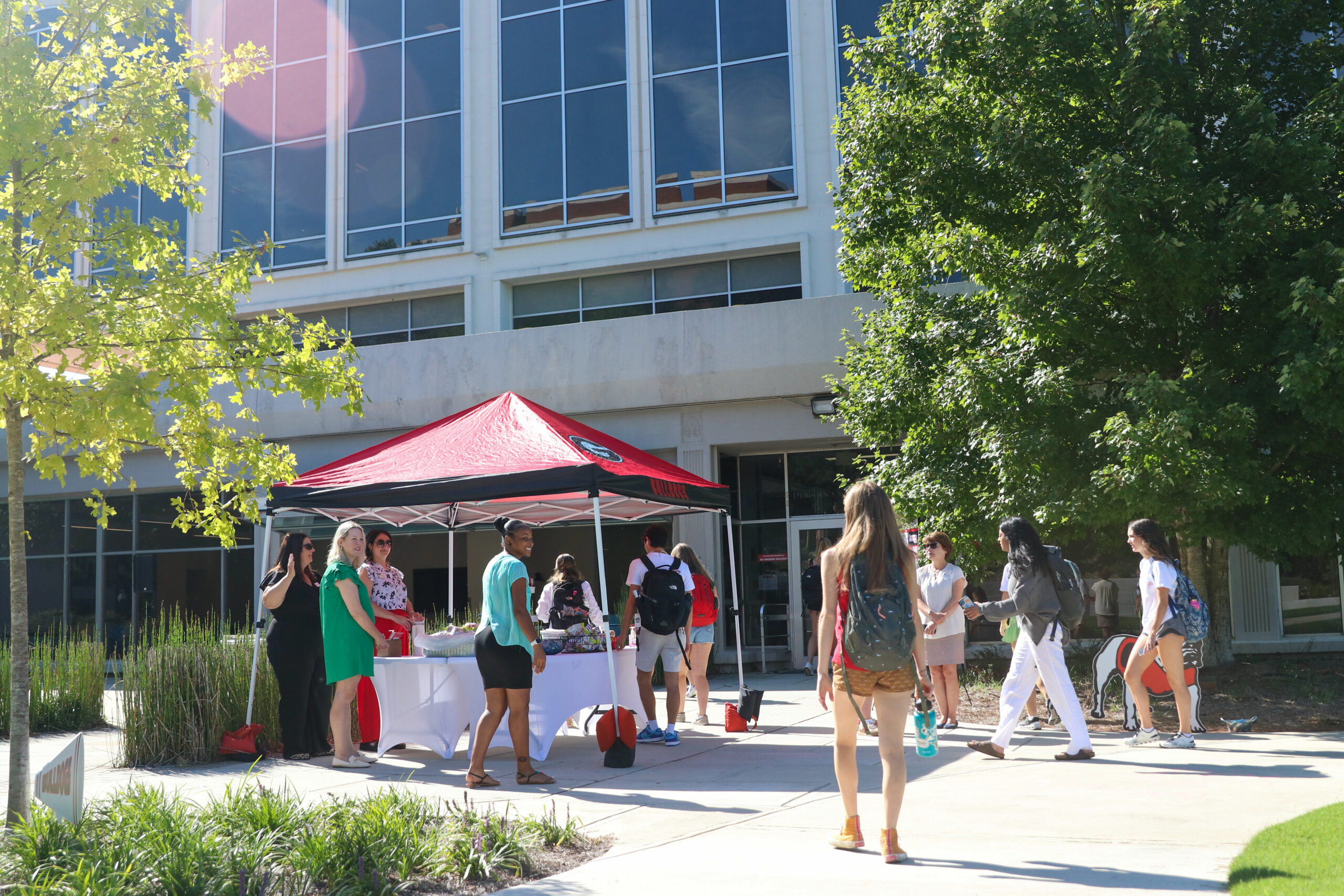 Students gathering around a tent and socializing at Grady College's Welcome Back Fall 2023 event.