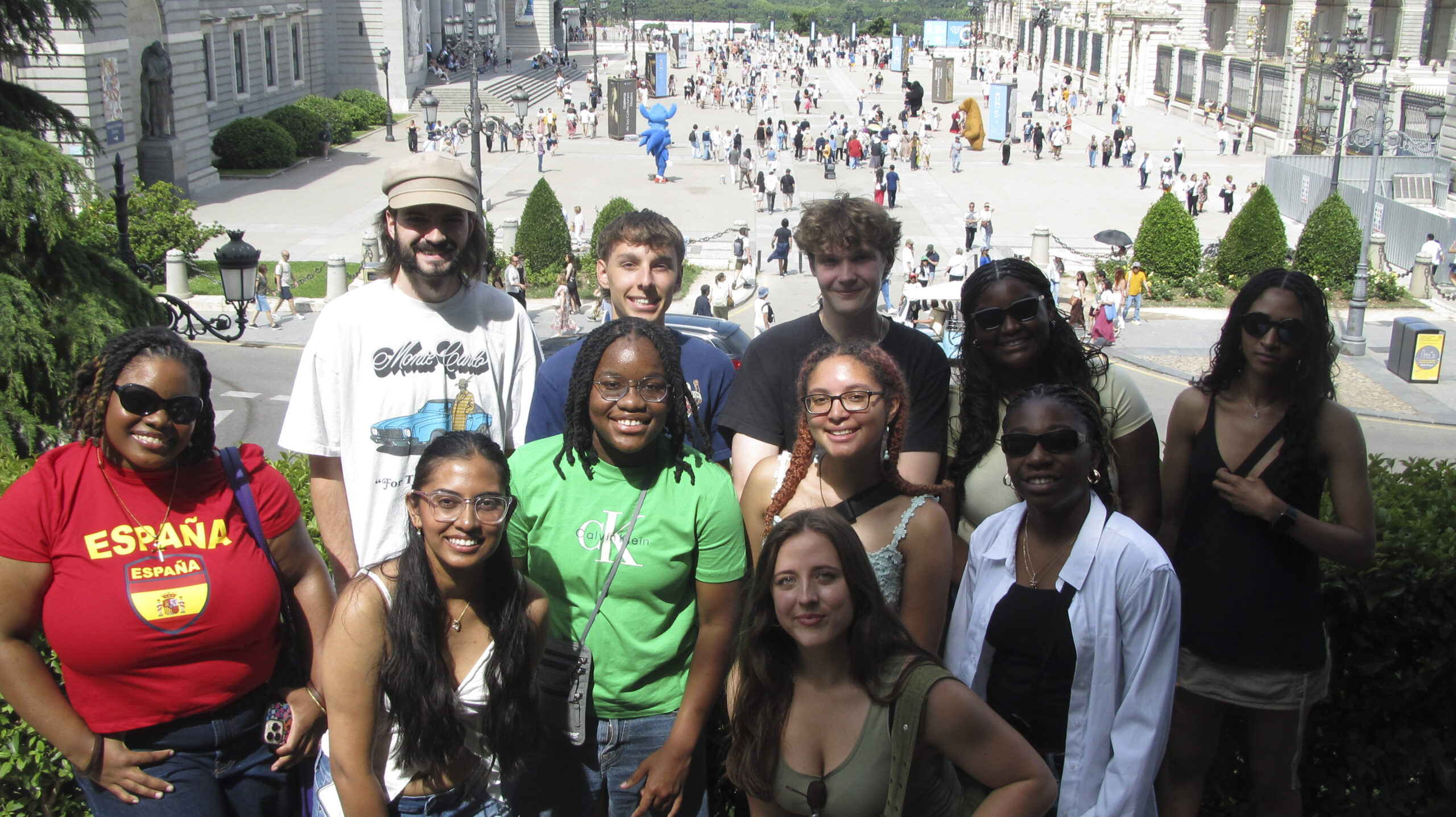 A group of students pose for a picture overlooking a central plaza.