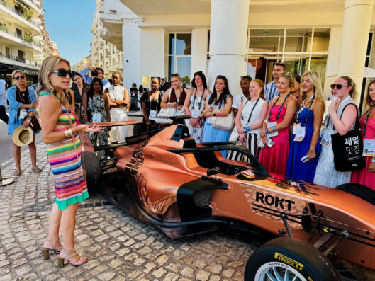Group of students look at racecar in Cannes.