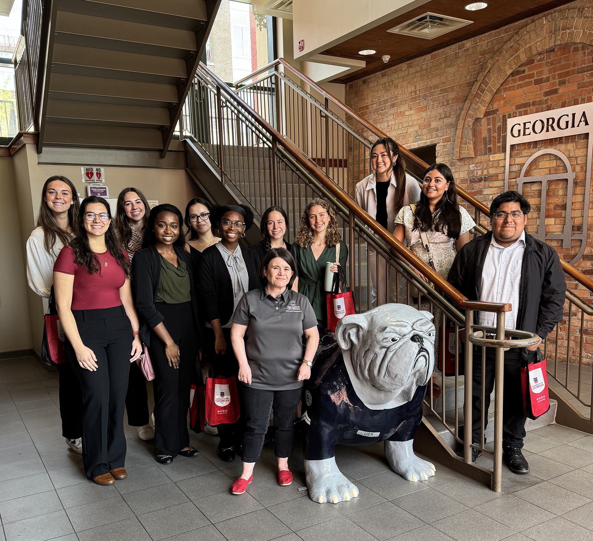 PRSSA members stand around a Bulldog statue.