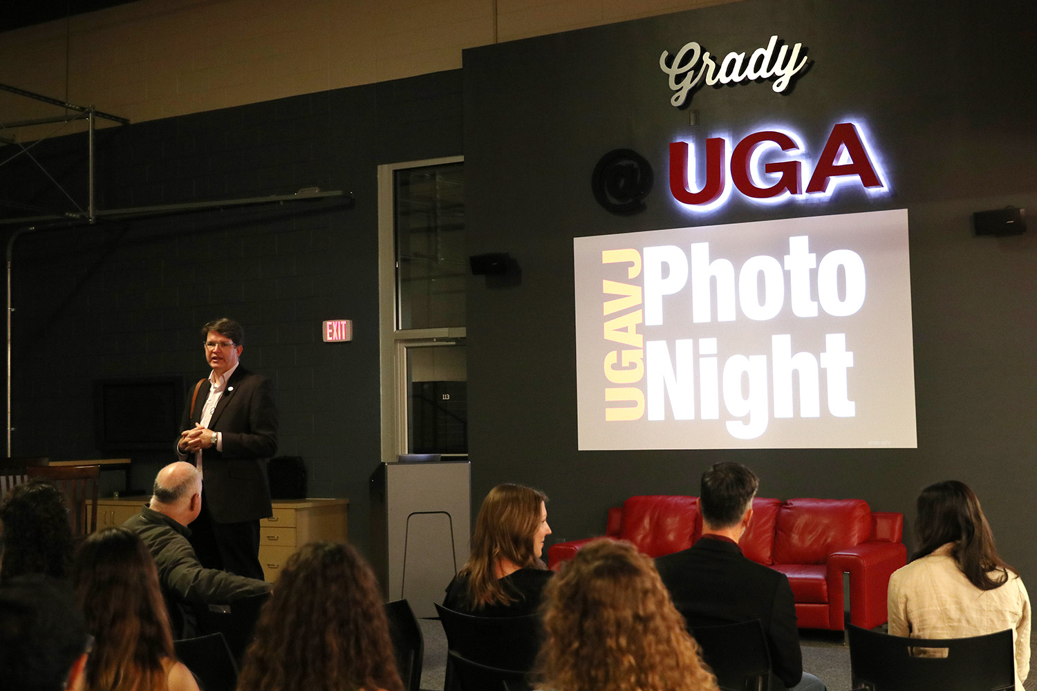 Mark Johnson stands in front of a slide that reads UGAVJ Photo Night.