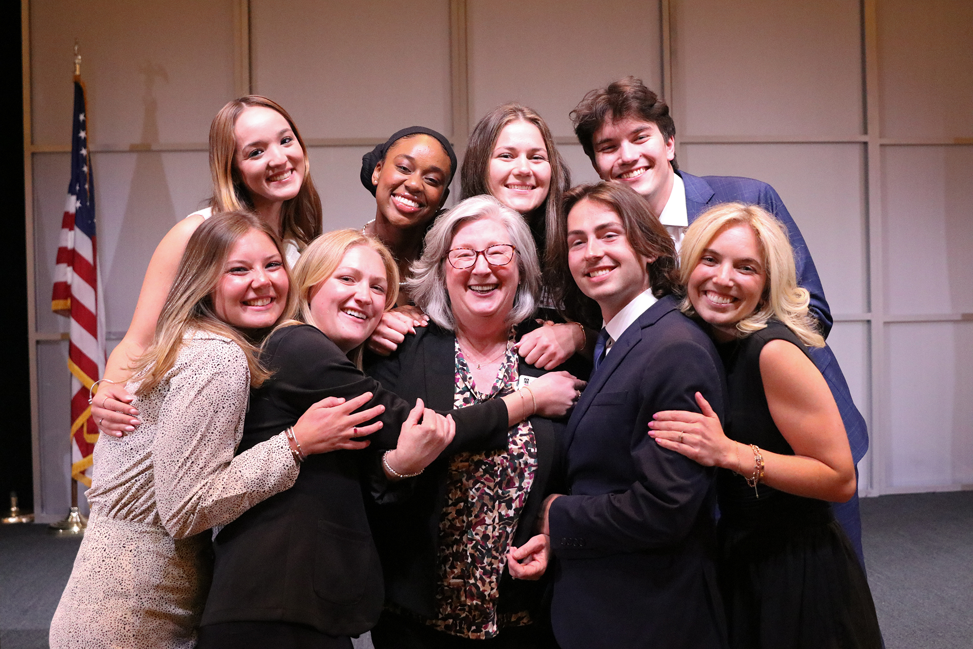 Students surround Mary Ellen Barto in a group hug.