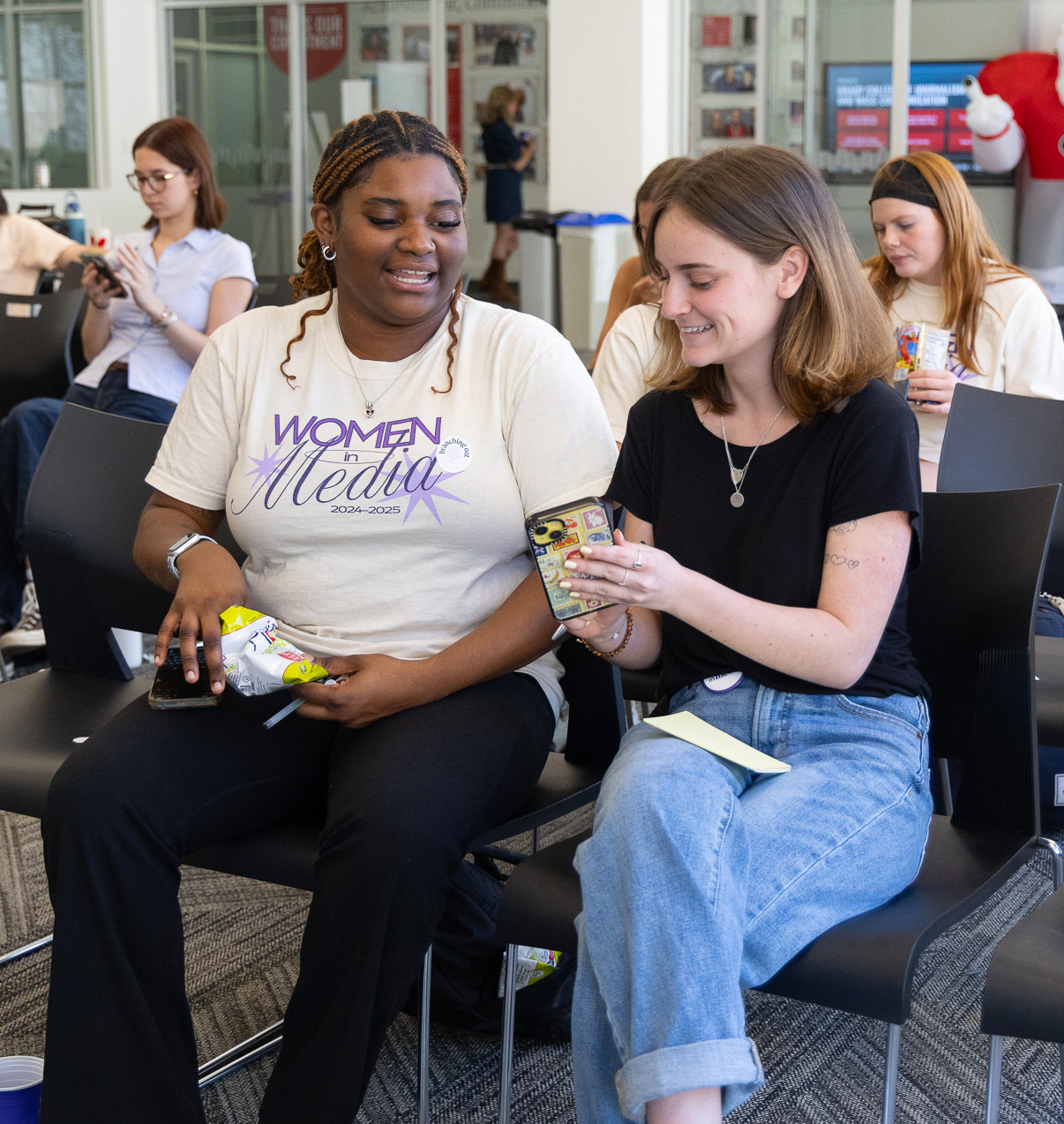 Two students look at a phone.