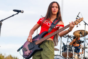 A musician plays bass in a band at the fair.