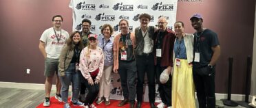 A group of people pose in front of a backdrop at the Austin Film Festival.