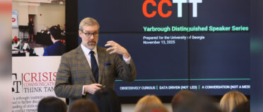 Simon Paterson makes a hand movement while he addresses a group of students. A screen in back of him reads CCTT: Yarbrough Distinguished Speaker Series.