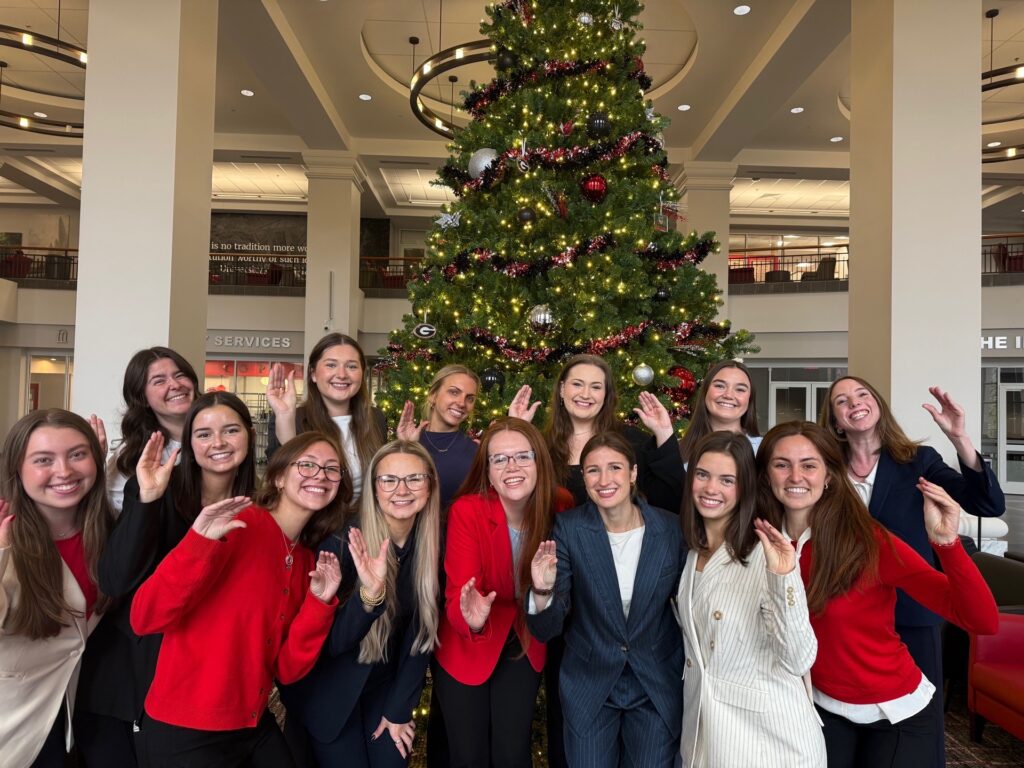 Members of the campaigns class smile after completing their final presentation for class, all holding up the Rock Lobsters "claw" hand sign.