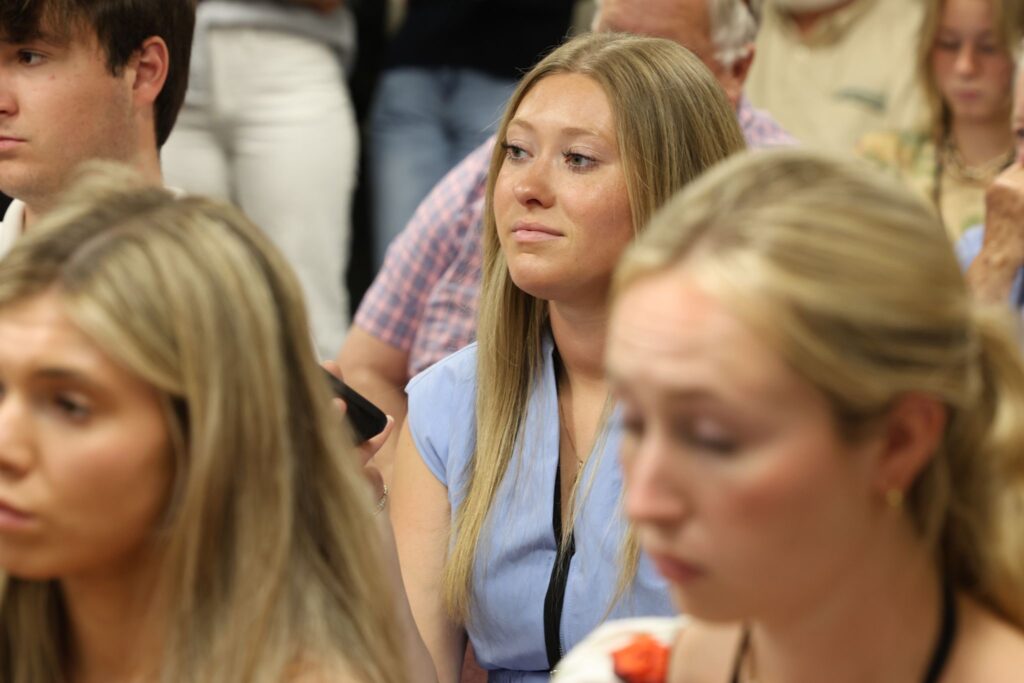 Emma Gladd is pictured sitting down amongst her peers at a Madison County Board of Commissioners meeting.