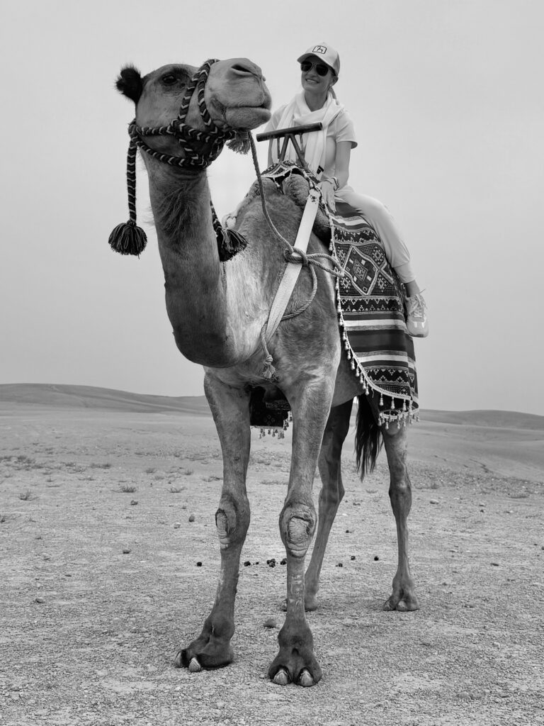Denham riding a camel in the desert
