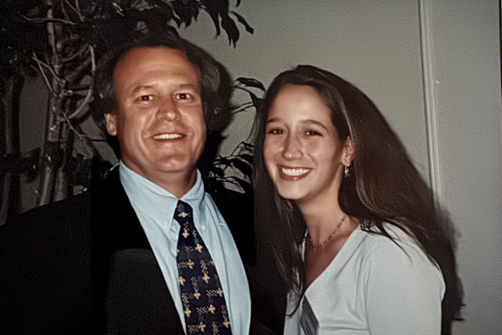 Robin Burnett is pictured smiling with her father at Grady College Convocation in 1999.