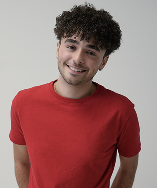 Photo of a young man in a red shirt posing for a headshot.